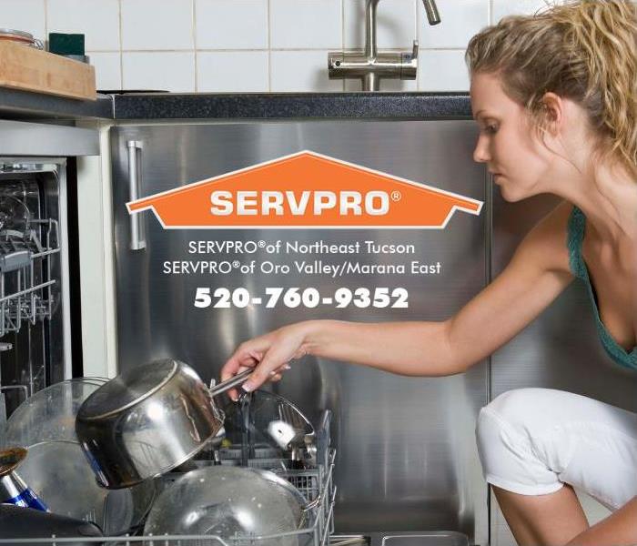 A woman is shown adding a dirty pot to a dishwasher. 