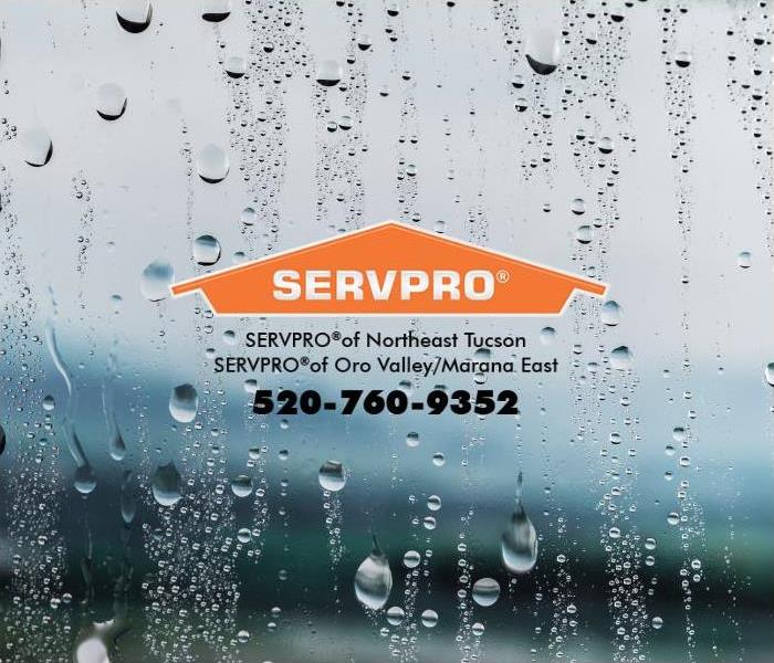 Raindrops are shown splashing on a window. 